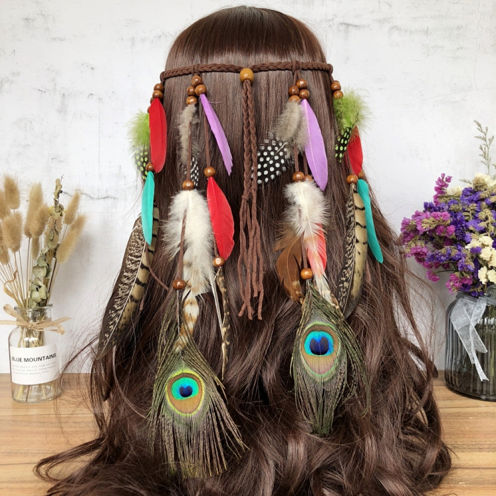 Boho leather cord hair band featuring a vibrant peacock feather, multi color feather tassels, and bead accents  displayed on a wooden surface with dried fresh flower arrangements 13