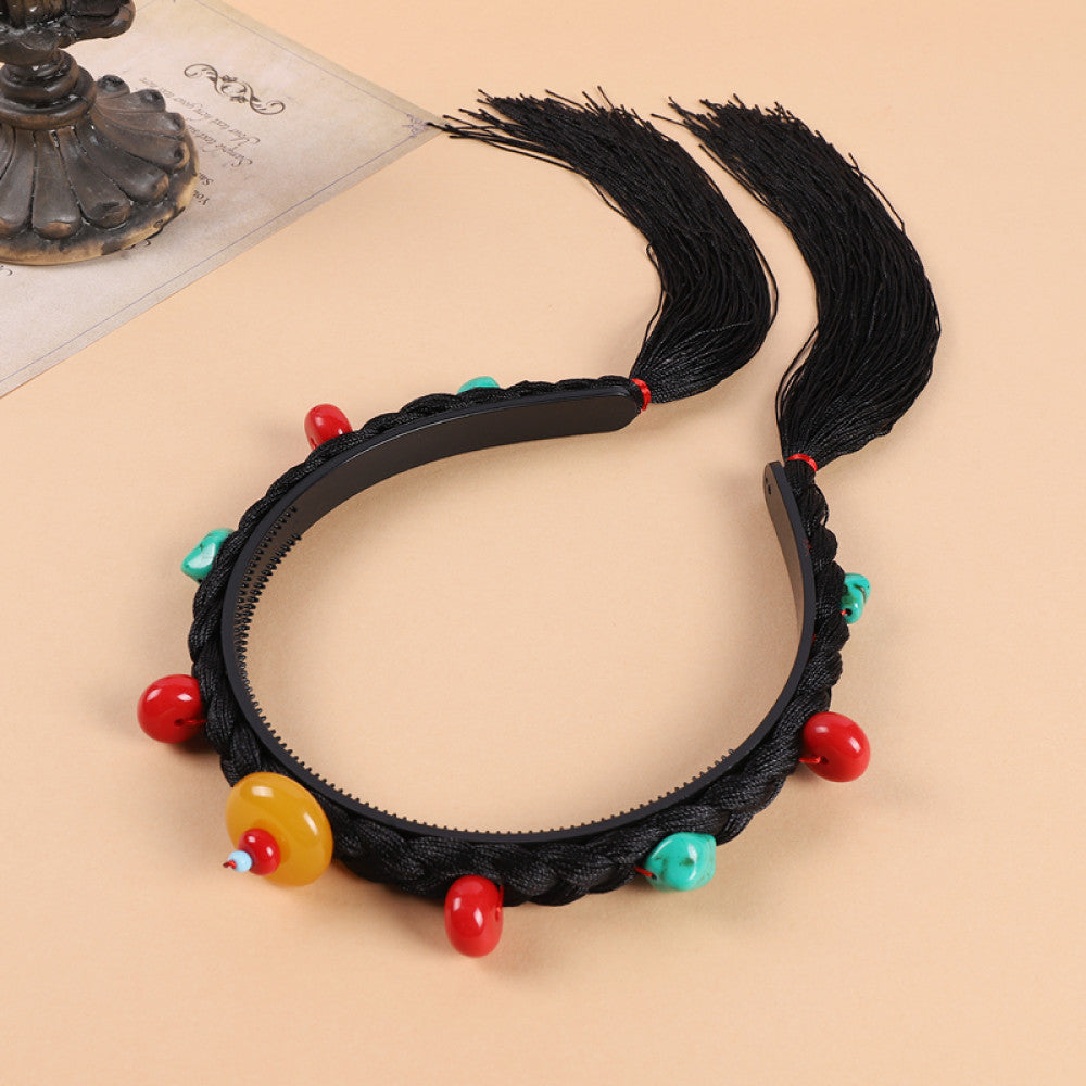 Boho vintage ethnic black braided hair hoop headband (displayed on a soft beige surface) featuring red beads, turquoise decorative pieces