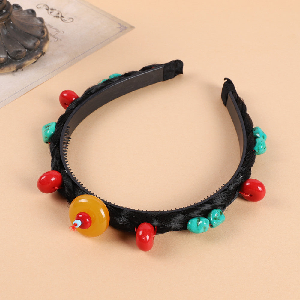 Boho vintage ethnic black braided hair hoop headband (displayed on a soft beige surface) featuring red beads, turquoise decorative pieces, and a yellow accent, ideal for bohemian retro fashion styling in the US