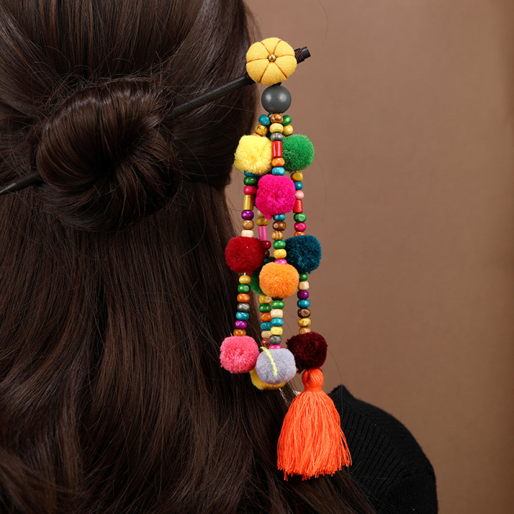 Boho vintage ethnic hair stick pendant featuring colorful pom poms, multi-color beaded accents, and a long orange tassel, displayed alongside an incense burner on a wooden surface against a brown background, ideal for bohemian and traditional fashion enthusiasts in the US 05