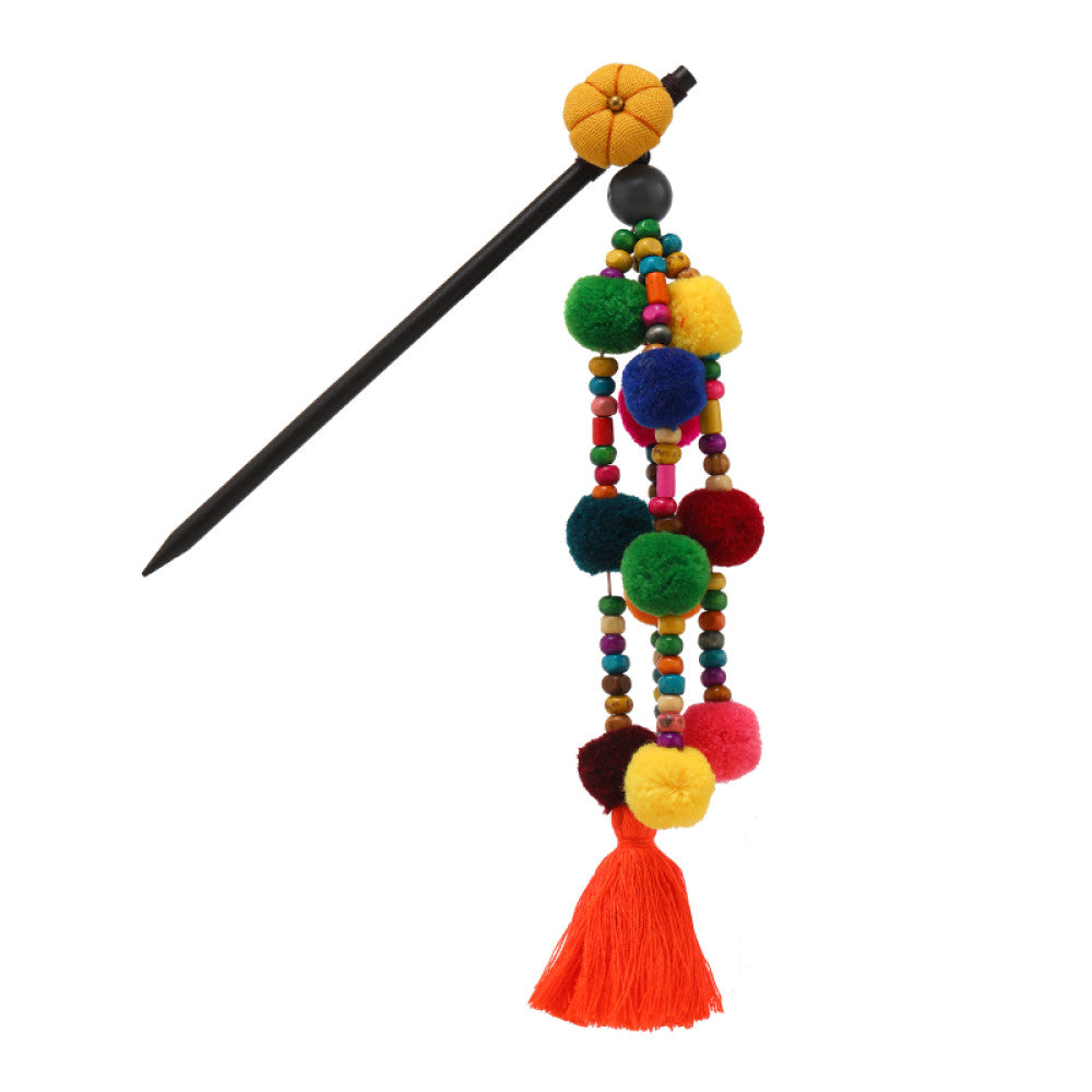 Boho vintage ethnic hair stick pendant featuring colorful pom poms, multi-color beaded accents, and a long orange tassel, displayed alongside an incense burner on a wooden surface against a brown background, ideal for bohemian and traditional fashion enthusiasts in the US 06