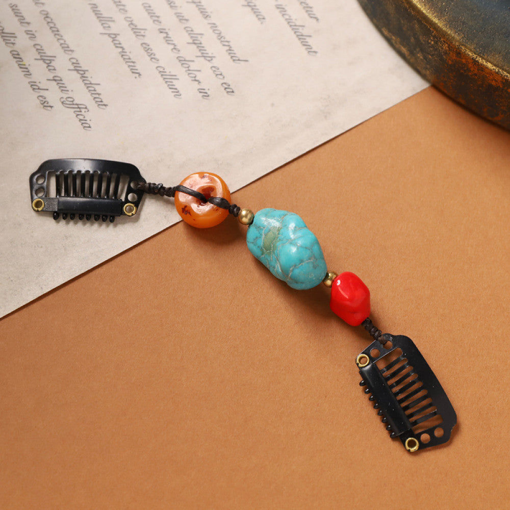 Boho vintage ethnic double hair comb ornament (displayed on a beige surface & text-printed paper background) featuring an evil eye decorative bead, red/yellow beads, and black hair combs 02