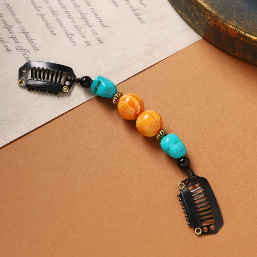 Boho vintage ethnic double hair comb ornament (displayed on a beige surface & text-printed paper background) featuring an evil eye decorative bead, red/yellow beads, and black hair combs 03