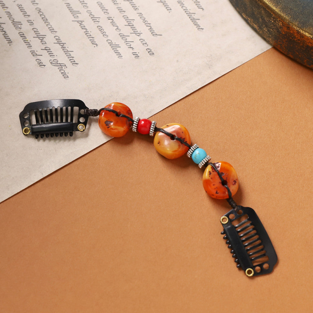 Boho vintage ethnic double hair comb ornament (displayed on a beige surface & text-printed paper background) featuring an evil eye decorative bead, red/yellow beads, and black hair combs, ideal for bohemian retro fashion styling in the US 02