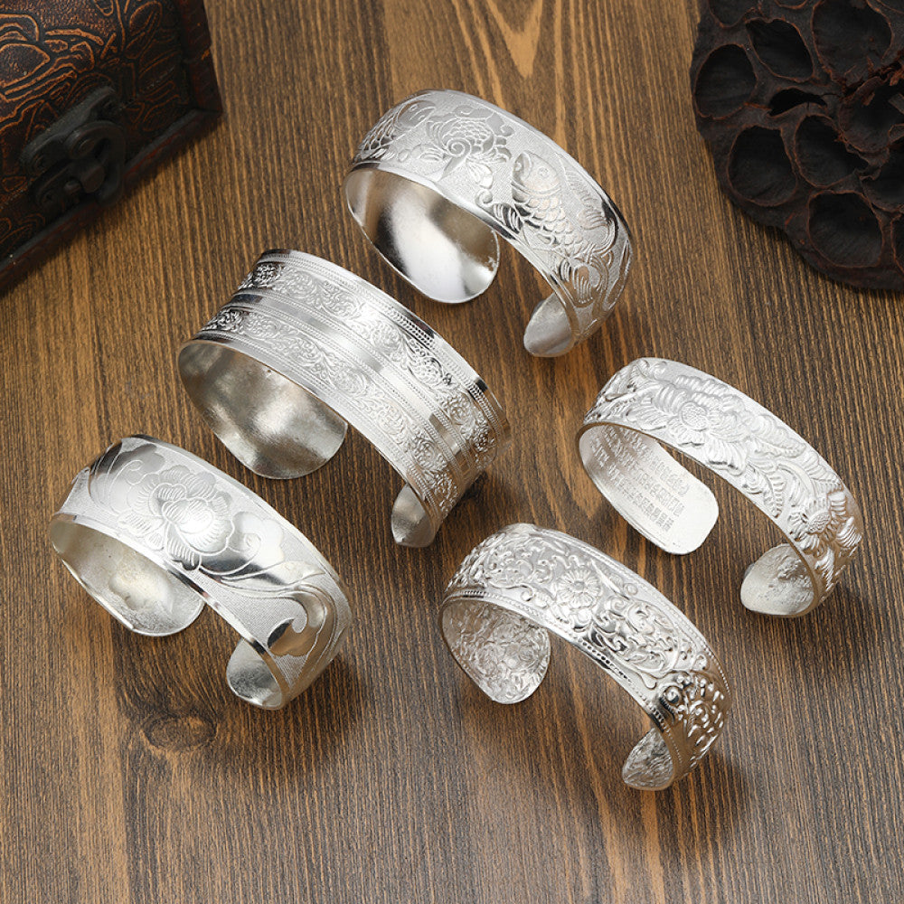 Assorted boho vintage ethnic engraved silver cuff bangle set with floral and tribal designs, styled on wooden surface, ideal for bohemian and tribal fashion enthusiasts in the US