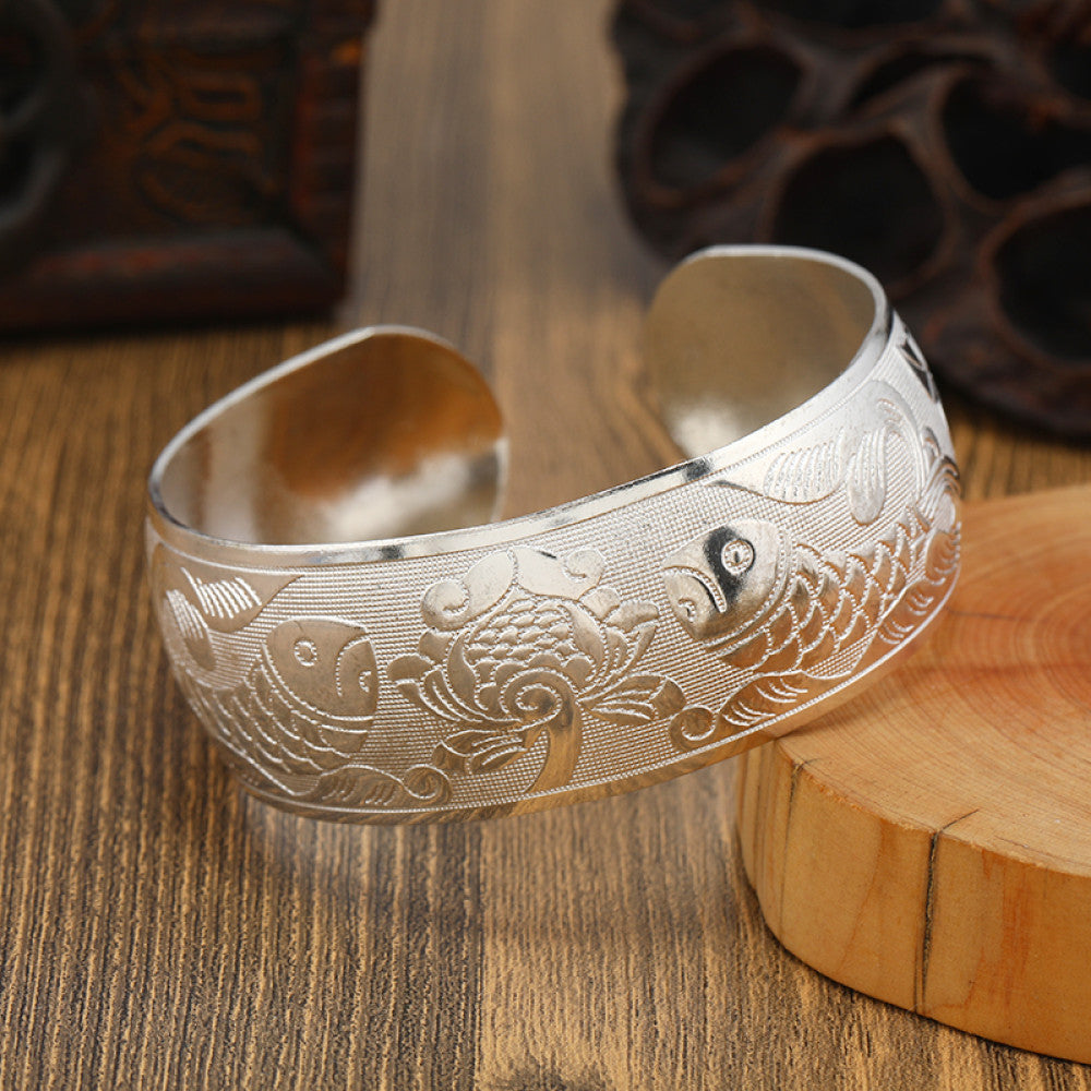 Boho vintage ethnic engraved silver cuff bangle with intricate floral designs, styled on wooden surface, ideal for bohemian and tribal fashion enthusiasts in the US 01