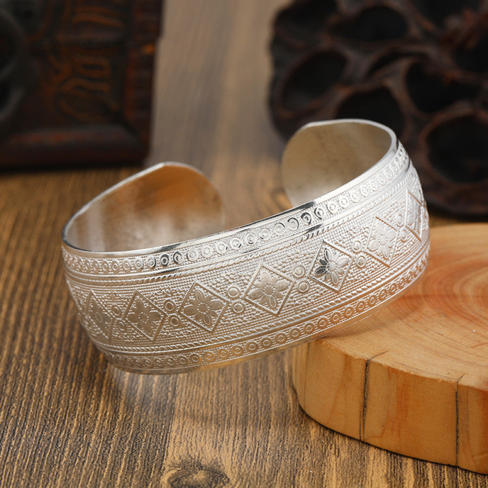 Boho vintage ethnic engraved silver cuff bangle with intricate floral designs, styled on wooden surface, ideal for bohemian and tribal fashion enthusiasts in the US 03