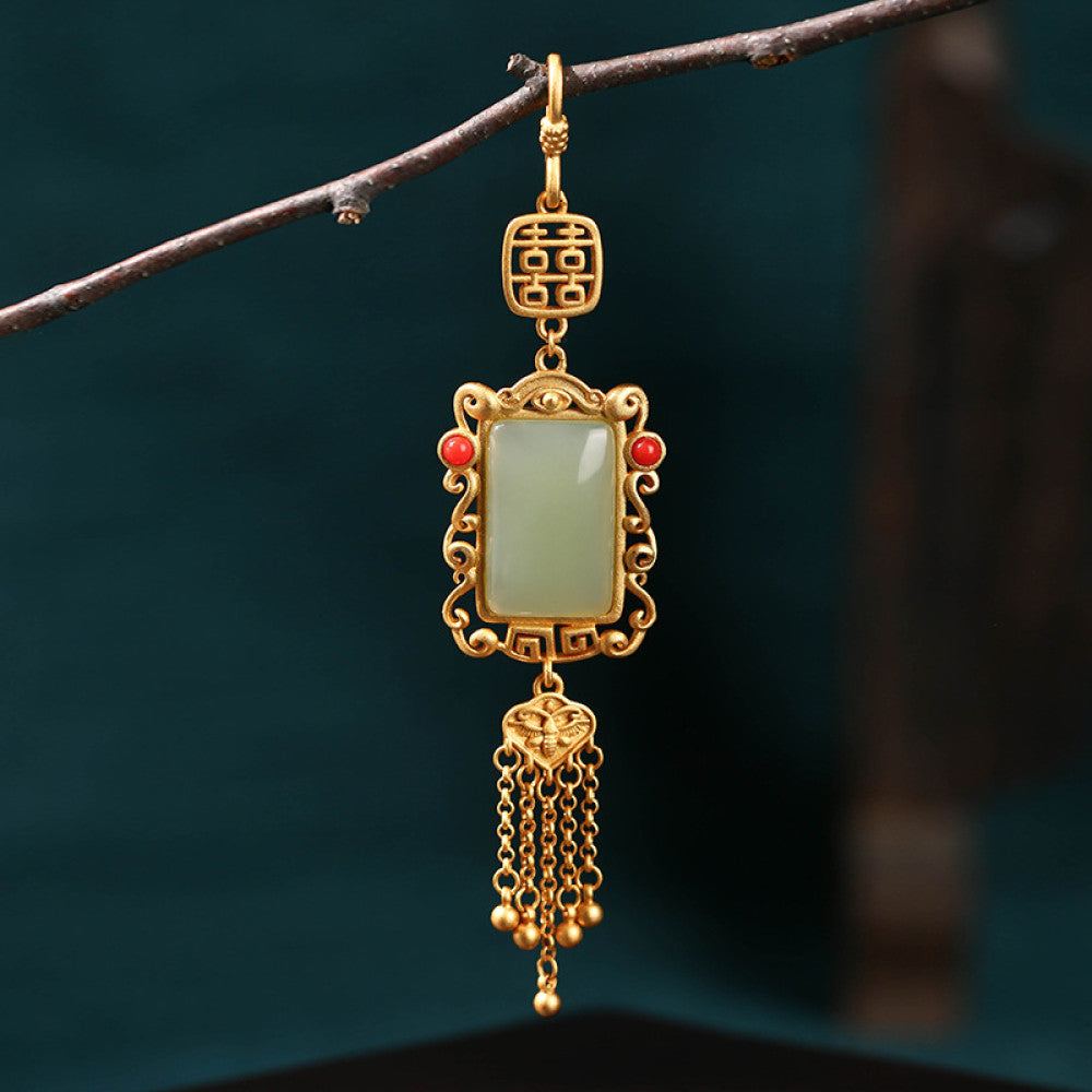 Boho vintage ethnic gold frame jade pendant featuring fu character, red accents and tassel details, styled on a tree branch, ideal for bohemian and traditional fashion enthusiasts in the US