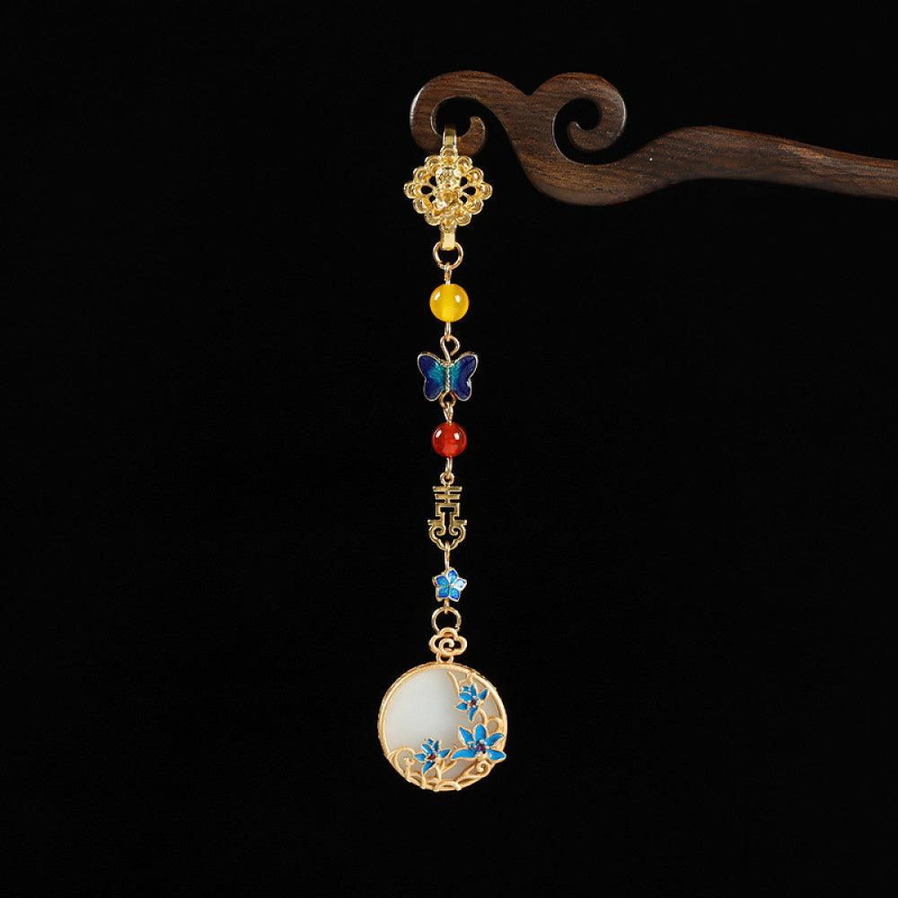 Boho vintage ethnic gold-tone hair pendant featuring butterfly decorative accent, Fu character detail, yellow/red/blue bead accents, and a white circular pendant with blue decorative detailing, styled on a wooden display hook against a black background, ideal for bohemian and traditional fashion enthusiasts in the US