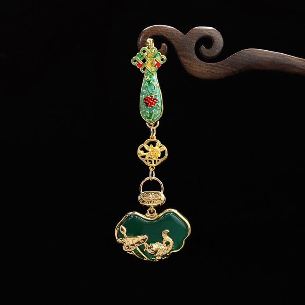 Boho vintage ethnic gold-tone hair pendant featuring green enamel accents, Chinese knot detail, and a carved green agate lock charm, styled on a wooden display hook, ideal for bohemian and traditional fashion enthusiasts in the US