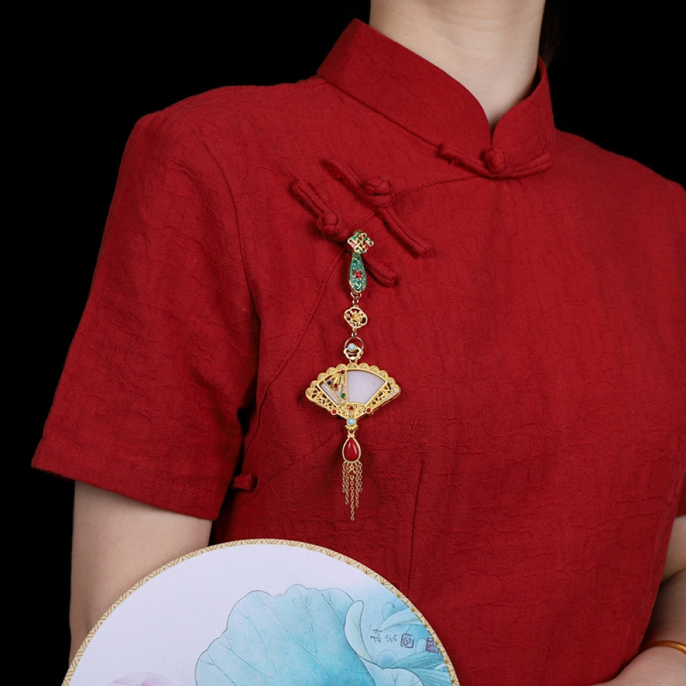 Boho vintage ethnic gold-tone hair pendant featuring green enamel detail, fan-shaped white shell charm, red gemstone accents and delicate tassel, styled on a wooden display hook, ideal for bohemian and traditional fashion enthusiasts in the US 01