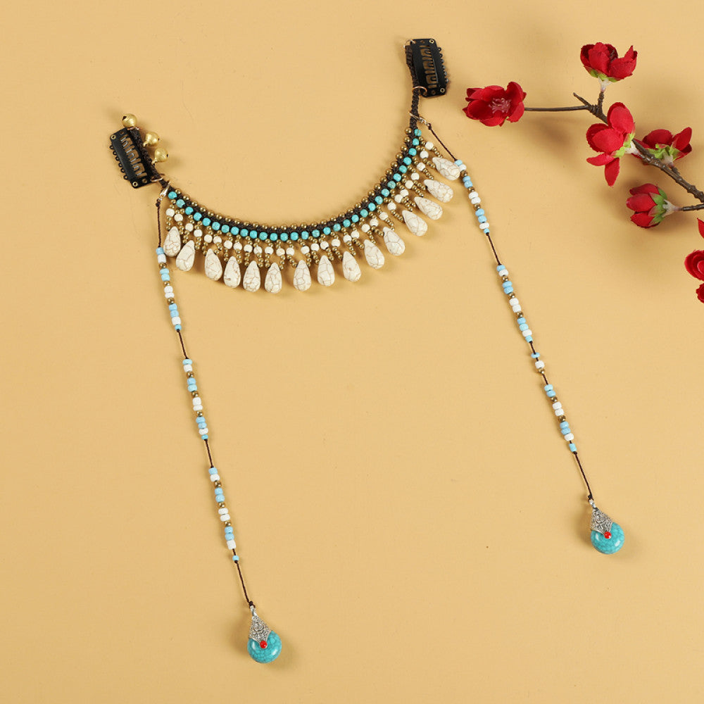 Boho vintage ethnic hair clip ornament featuring red coral-style beads, turquoise accents, and long dangle tassel pendants, displayed on a warm yellow background 