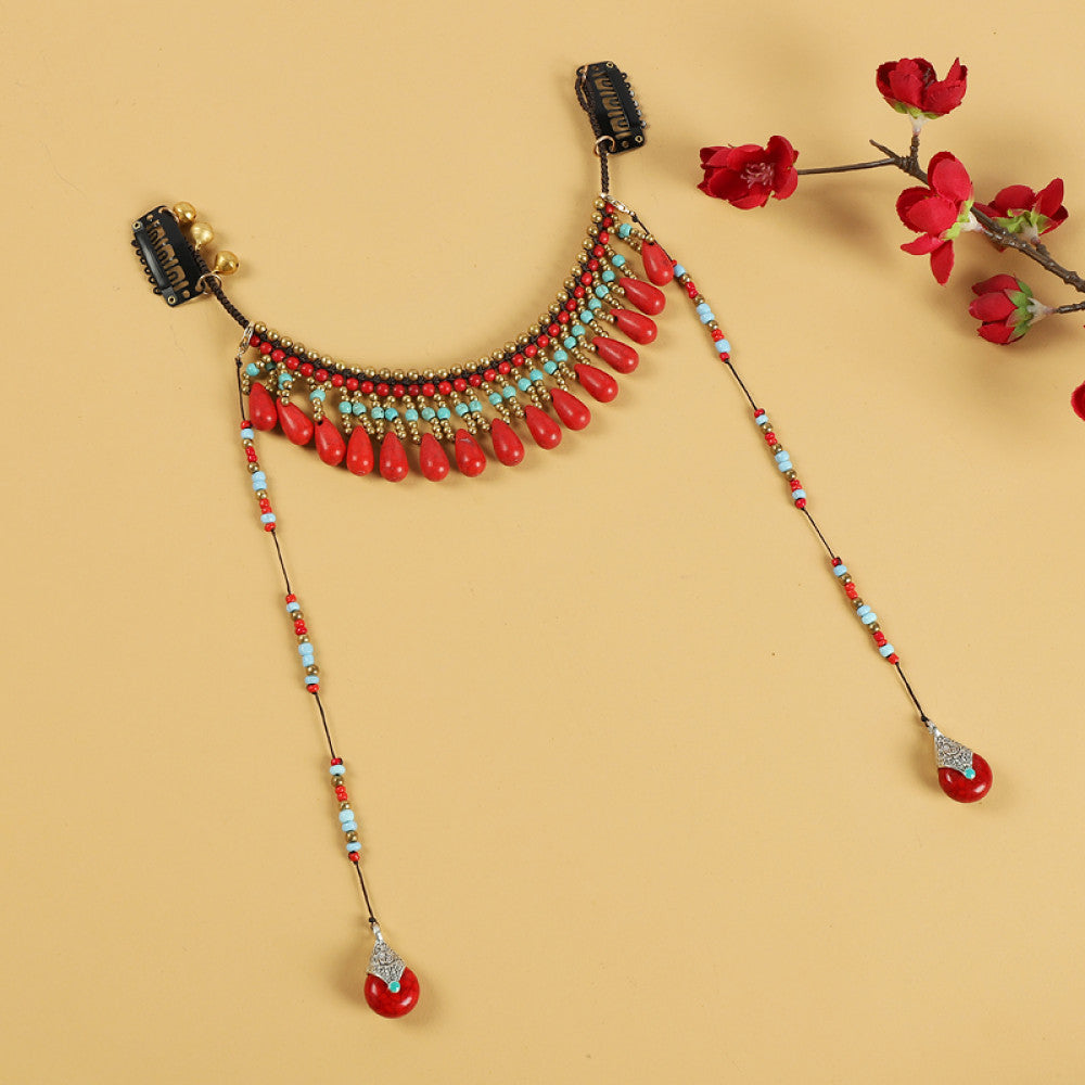 Boho vintage ethnic hair clip ornament (with hair clips) featuring red coral-style beads, turquoise accents, and long dangle tassel pendants, displayed on a warm yellow background (alongside red flower branches), ideal for bohemian traditional fashion styling in the US
