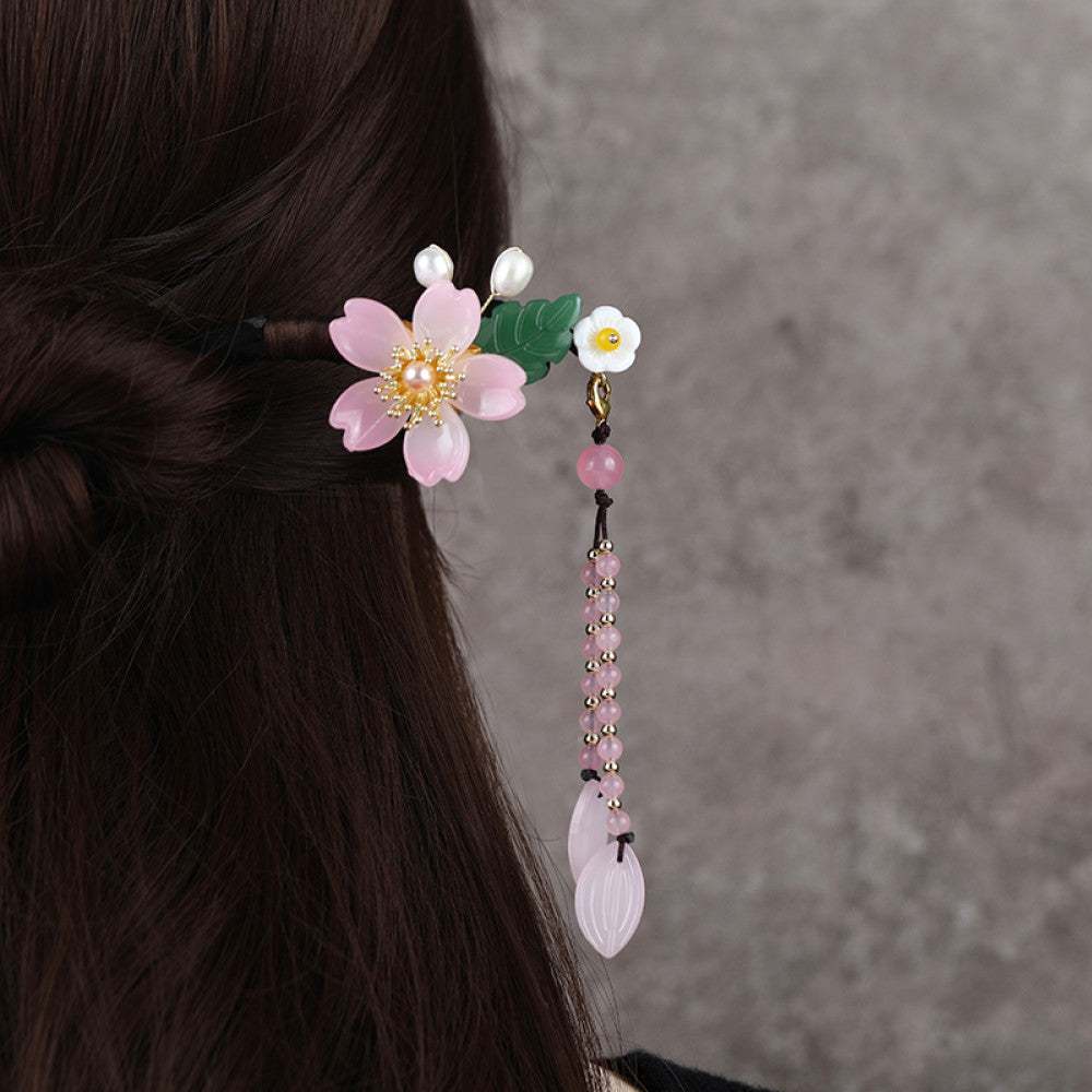 Boho vintage ethnic hair stick ornament featuring a pink flower green leaf accents, pink/green bead tassel, and light green leaf pendant, displayed against a muted gray background 01