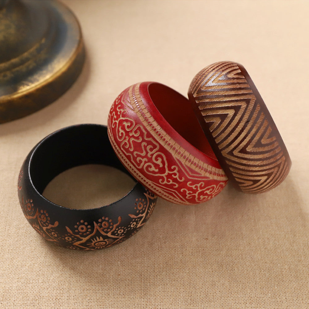 Assorted boho vintage ethnic wood bangle set with carved tribal, floral, geometric designs, styled on burlap surface, ideal for bohemian and tribal fashion enthusiasts in the US 01