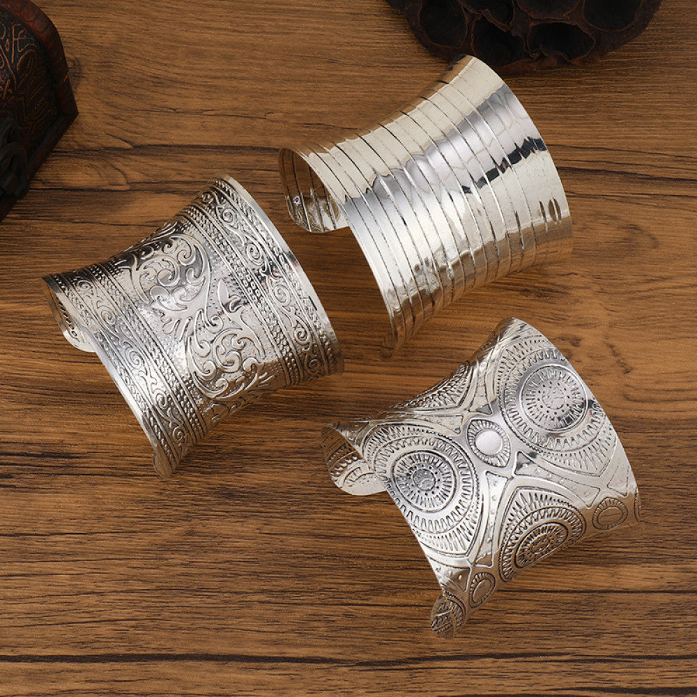 Assorted boho vintage ethnic silver cuff bangle set with mixed engraved designs, styled on wooden surface, ideal for bohemian and tribal fashion enthusiasts