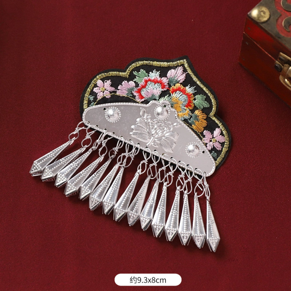 Boho vintage ethnic silver-tone decorative ornament featuring intricate silver-tone detailing, embroidered accent and multiple bell tassel pendants, displayed on a red fabric background 02