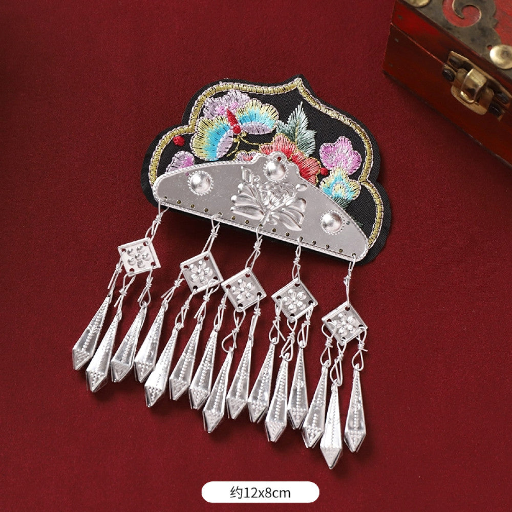 Boho vintage ethnic silver-tone decorative ornament featuring intricate silver-tone detailing, embroidered accent and multiple bell tassel pendants, displayed on a red fabric background 06