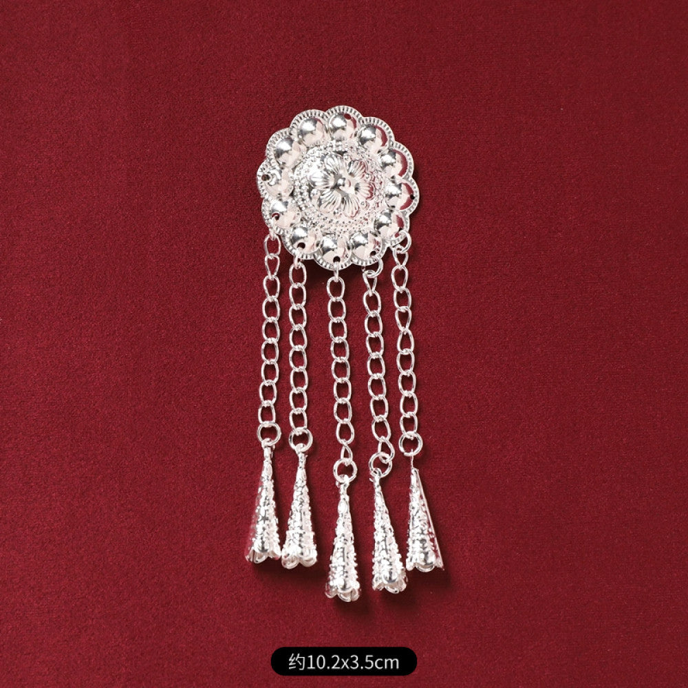 Boho vintage ethnic silver-tone decorative pendant featuring an intricate round patterned center, multiple silver-tone fish charms, and layered bell tassel fringe, displayed on a rich red fabric background, ideal for bohemian and traditional fashion styling in the US 02