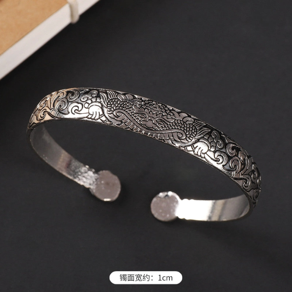 Vintage boho ethnic silver-tone cuff bracelet with dragon and phoenix engravings, styled on a black surface, ideal for bohemian and cultural fashion enthusiasts in the US 05
