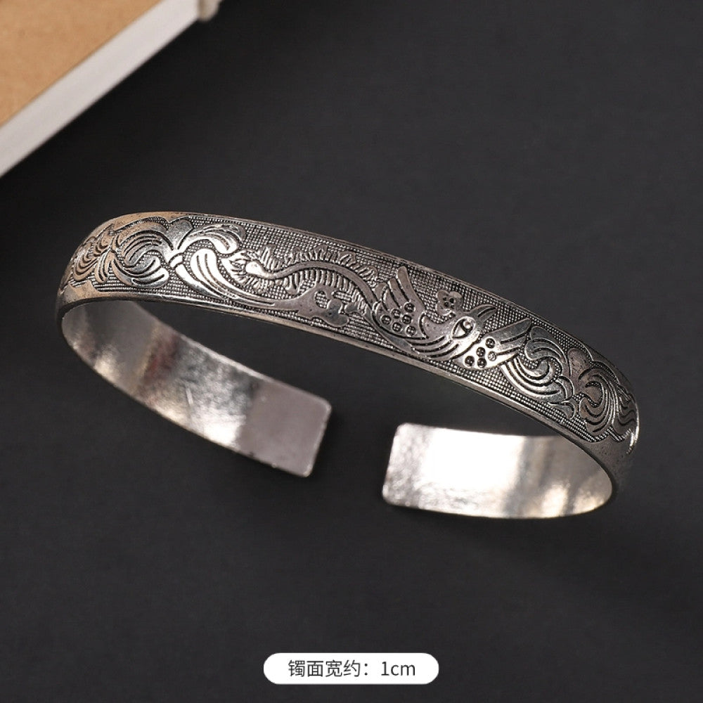 Vintage boho ethnic silver-tone cuff bracelet with dragon and phoenix engravings, styled on a black surface, ideal for bohemian and cultural fashion enthusiasts in the US 07