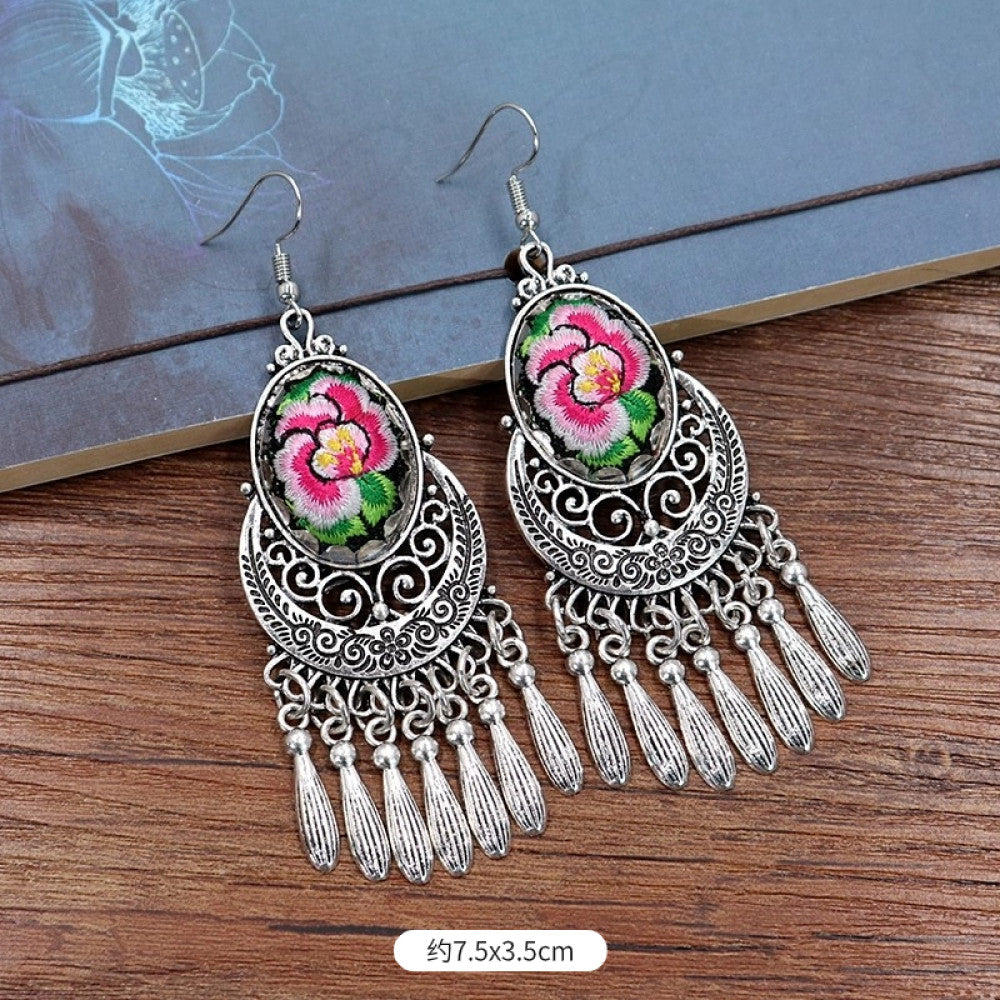 Boho vintage ethnic silver-tone earrings set (displayed on a wooden surface with a patterned notebook background) featuring embroidered lotus details and layered silver bell fringe pendants 04