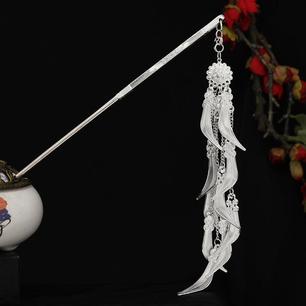 Boho vintage ethnic silver-tone hair stick featuring detailed textured handle, intricate chain network decor, and layered silver tassel pendants, displayed against a black background with red floral accents 12