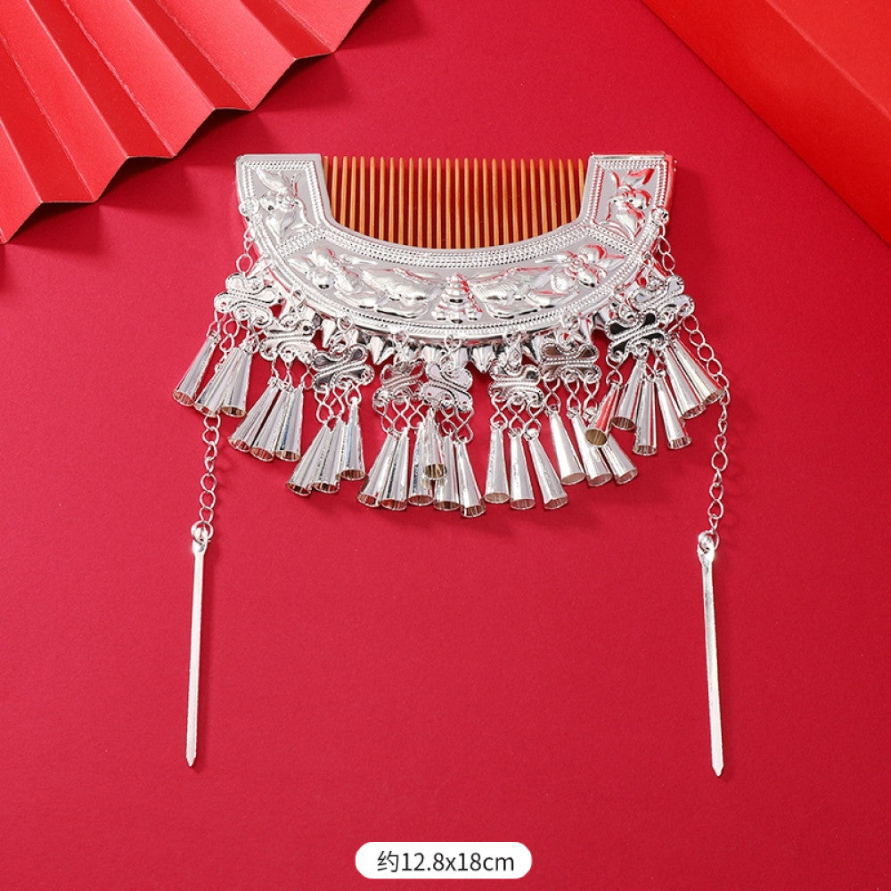 Boho vintage ethnic silver-tone hair stick (hand-held display against a rich red background alongside a red folding fan) featuring intricate openwork details and layered tassel fringe 01