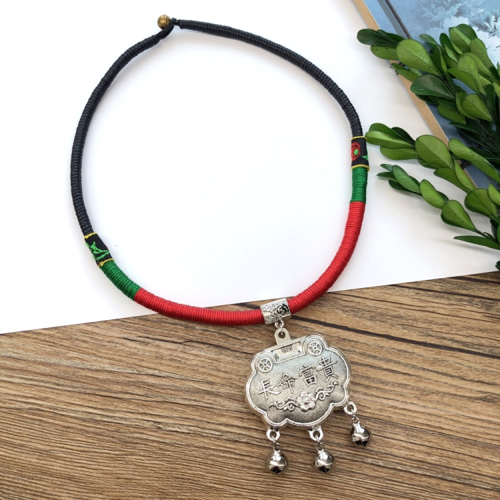 Boho vintage ethnic tri-color rope choker necklace, featuring a silver-tone ornate fringe pendant with colorful bead details, displayed on a wooden surface 01