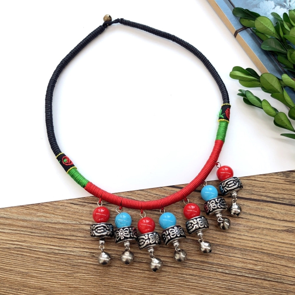 Boho vintage ethnic tri-color rope choker necklace, featuring a silver-tone ornate fringe pendant with colorful bead details, displayed on a wooden surface 02