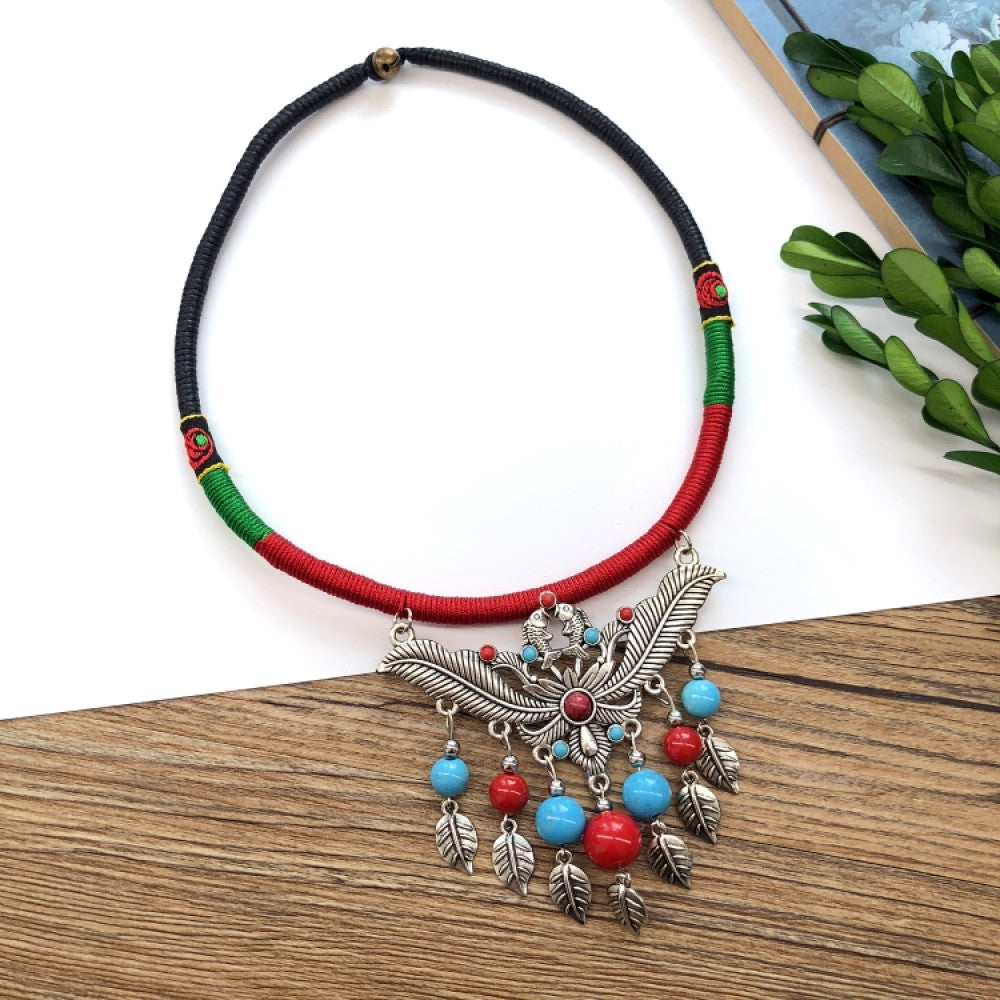 Boho vintage ethnic tri-color rope choker necklace, featuring a silver-tone ornate fringe pendant with colorful bead details, displayed on a wooden surface 03