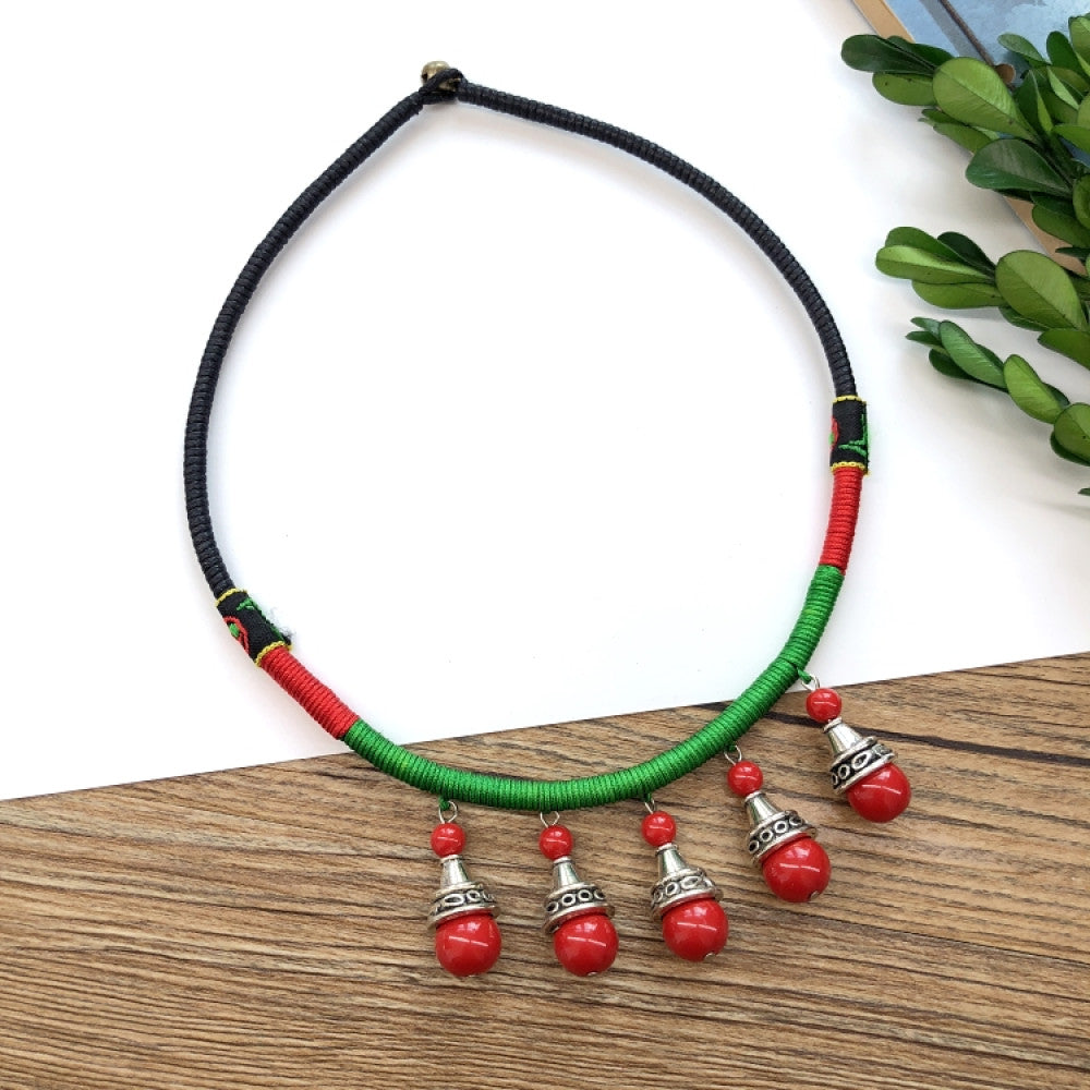 Boho vintage ethnic tri-color rope choker necklace, featuring a silver-tone ornate fringe pendant with colorful bead details, displayed on a wooden surface 04