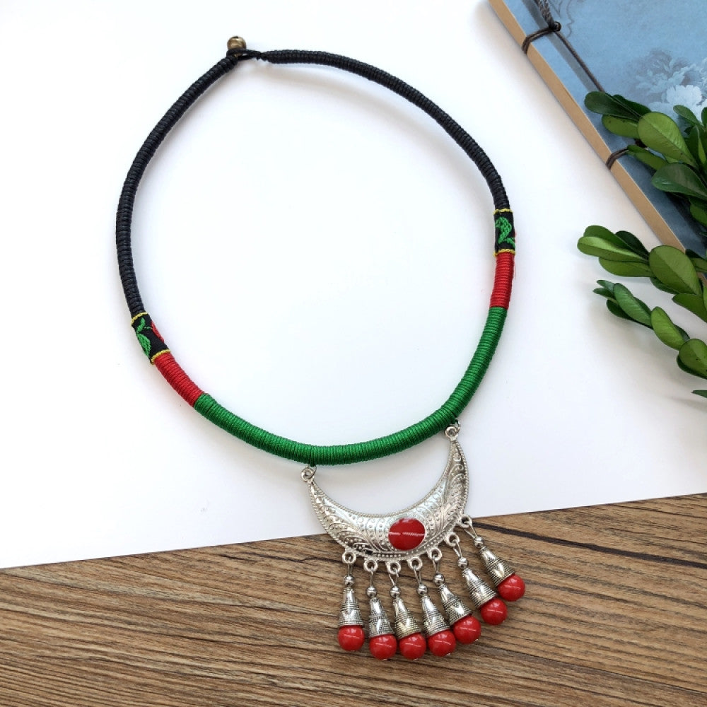 Boho vintage ethnic tri-color rope choker necklace, featuring a silver-tone ornate fringe pendant with colorful bead details, displayed on a wooden surface 06