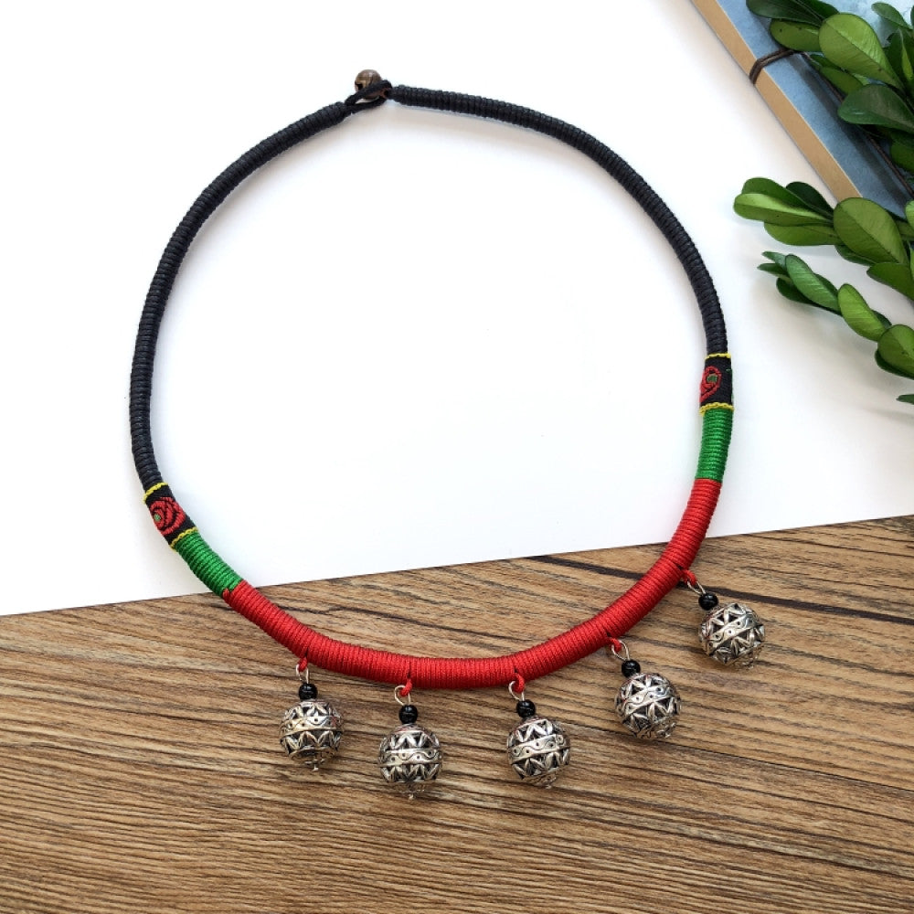 Boho vintage ethnic tri-color rope choker necklace, featuring a silver-tone ornate fringe pendant with colorful bead details, displayed on a wooden surface 07
