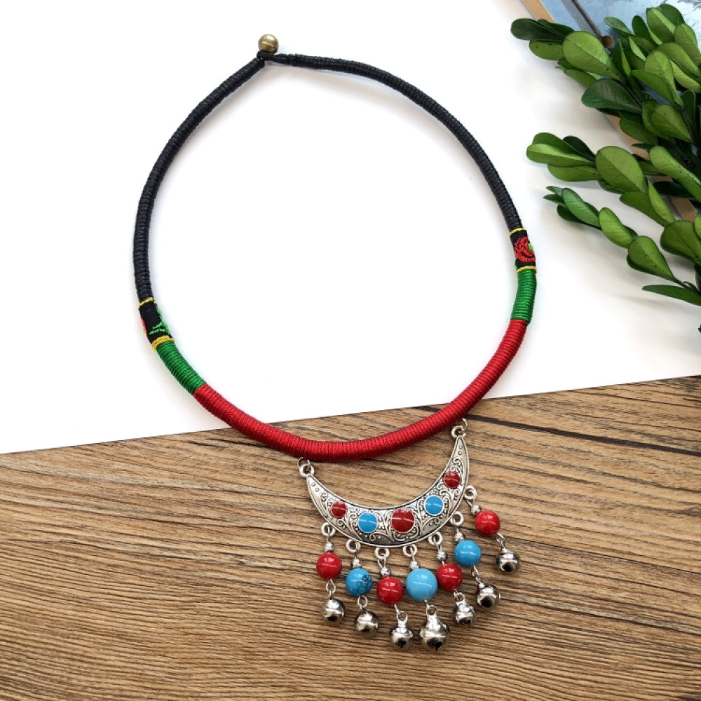 Boho vintage ethnic tri-color (black/red/green) rope choker necklace, featuring a silver-tone ornate fringe pendant with colorful bead details, displayed on a wooden surface (paired with white background, green foliage & a notebook), ideal for bohemian casual fashion styling in the US 03