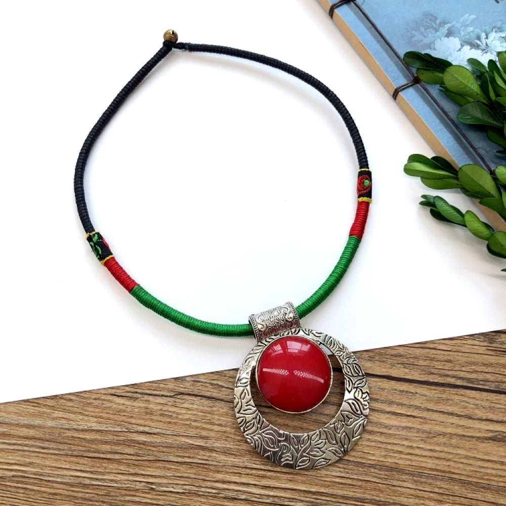 Boho vintage ethnic tri-color (black/red/green) rope choker necklace, featuring a silver-tone ornate fringe pendant with colorful bead details, displayed on a wooden surface (paired with white background, green foliage & a notebook), ideal for bohemian casual fashion styling in the US 05
