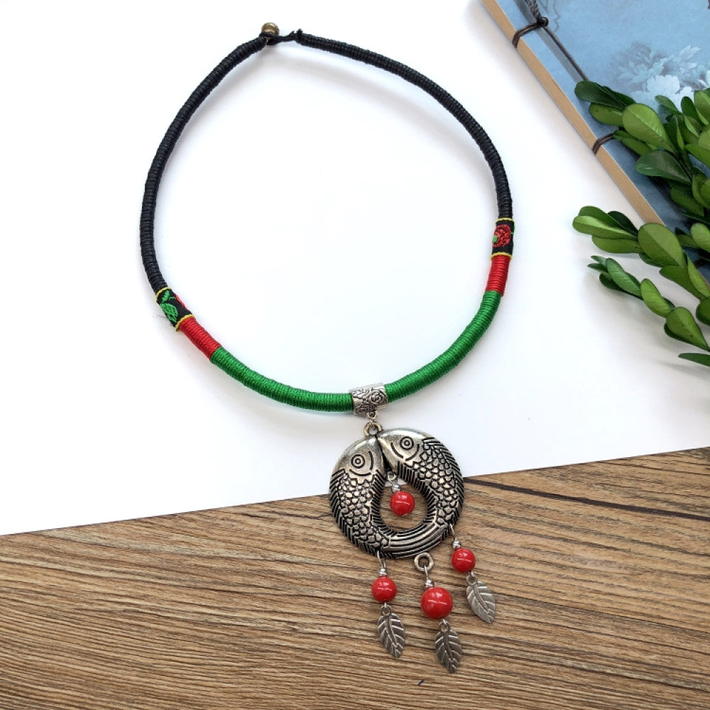 Boho vintage ethnic tri-color (black/red/green) rope choker necklace, featuring a silver-tone ornate fringe pendant with colorful bead details, displayed on a wooden surface (paired with white background, green foliage & a notebook), ideal for bohemian casual fashion styling in the US 06