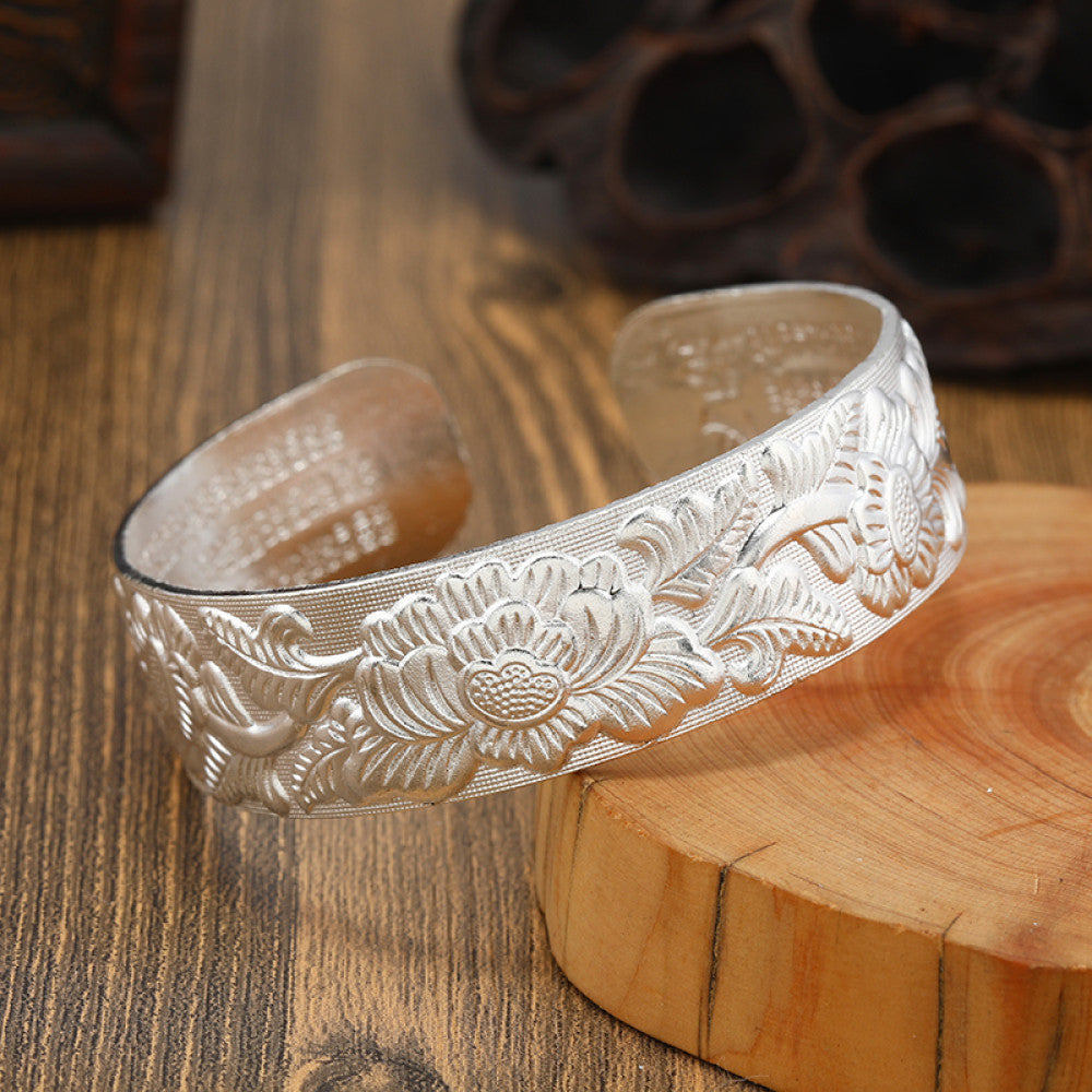 Boho vintage ethnic silver cuff bangle with tribal geometric engravings, styled on wooden surface, perfect for bohemian and tribal fashion lovers in the US 04