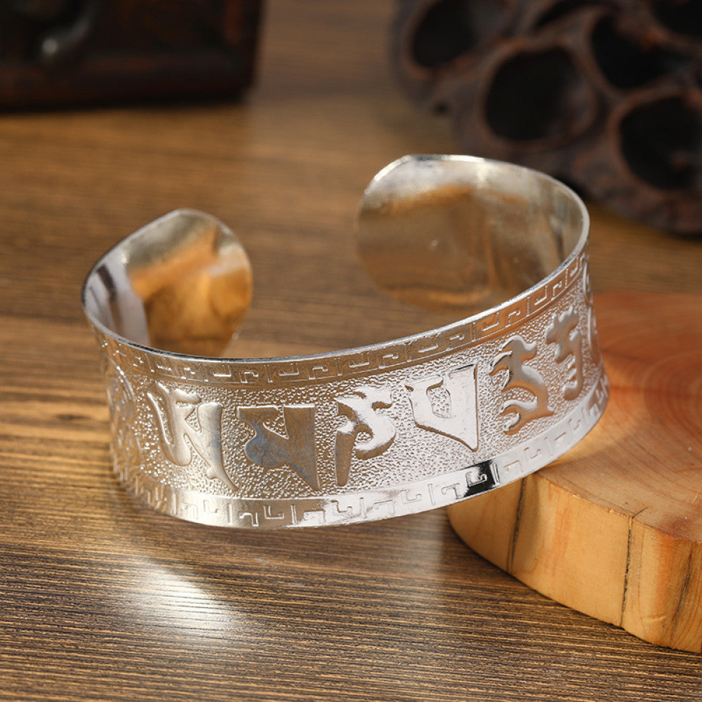 Boho vintage ethnic silver cuff bangle with tribal geometric engravings, styled on wooden surface, perfect for bohemian and tribal fashion lovers in the US 08