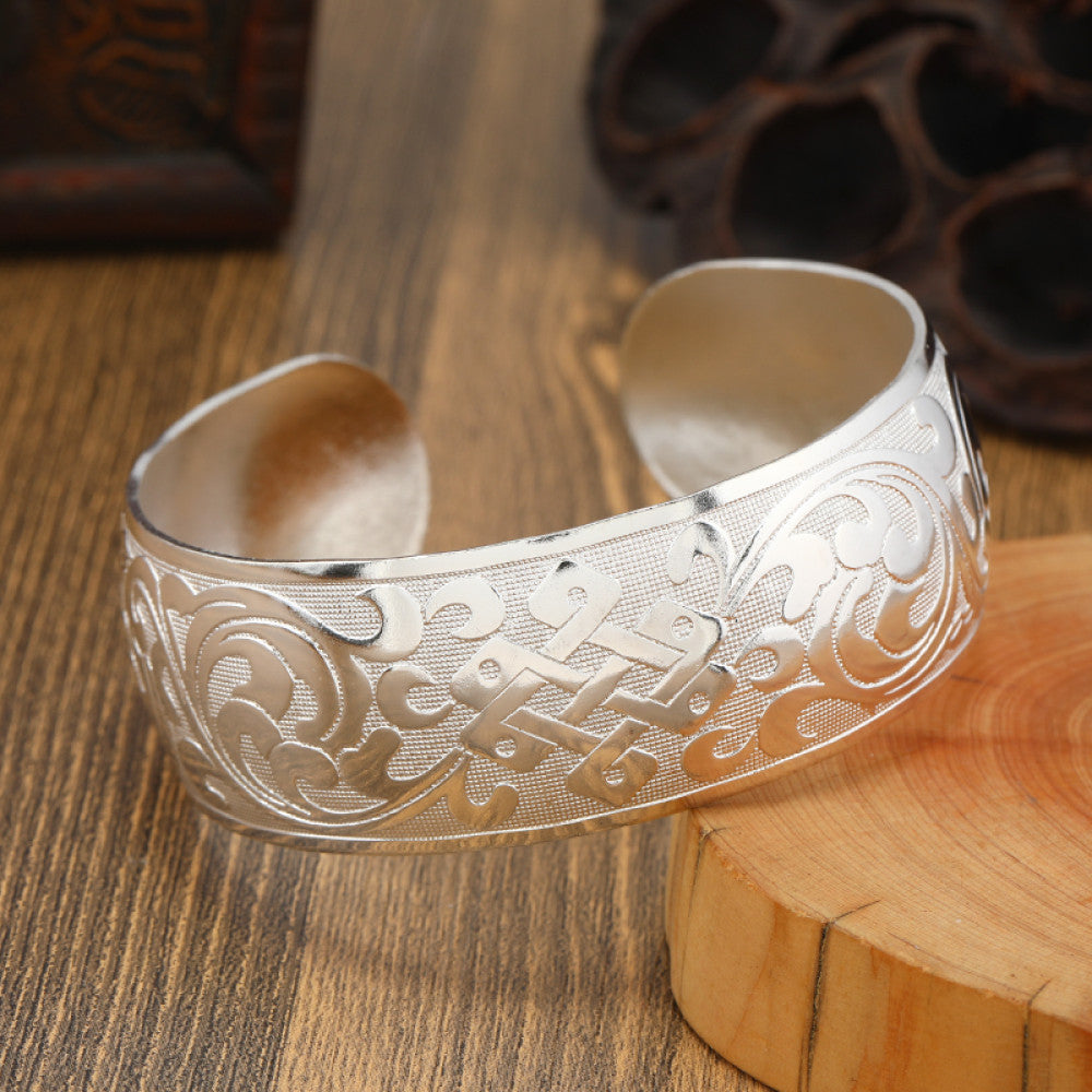Boho vintage ethnic silver cuff bangle with tribal geometric engravings, styled on wooden surface, perfect for bohemian and tribal fashion lovers in the US10