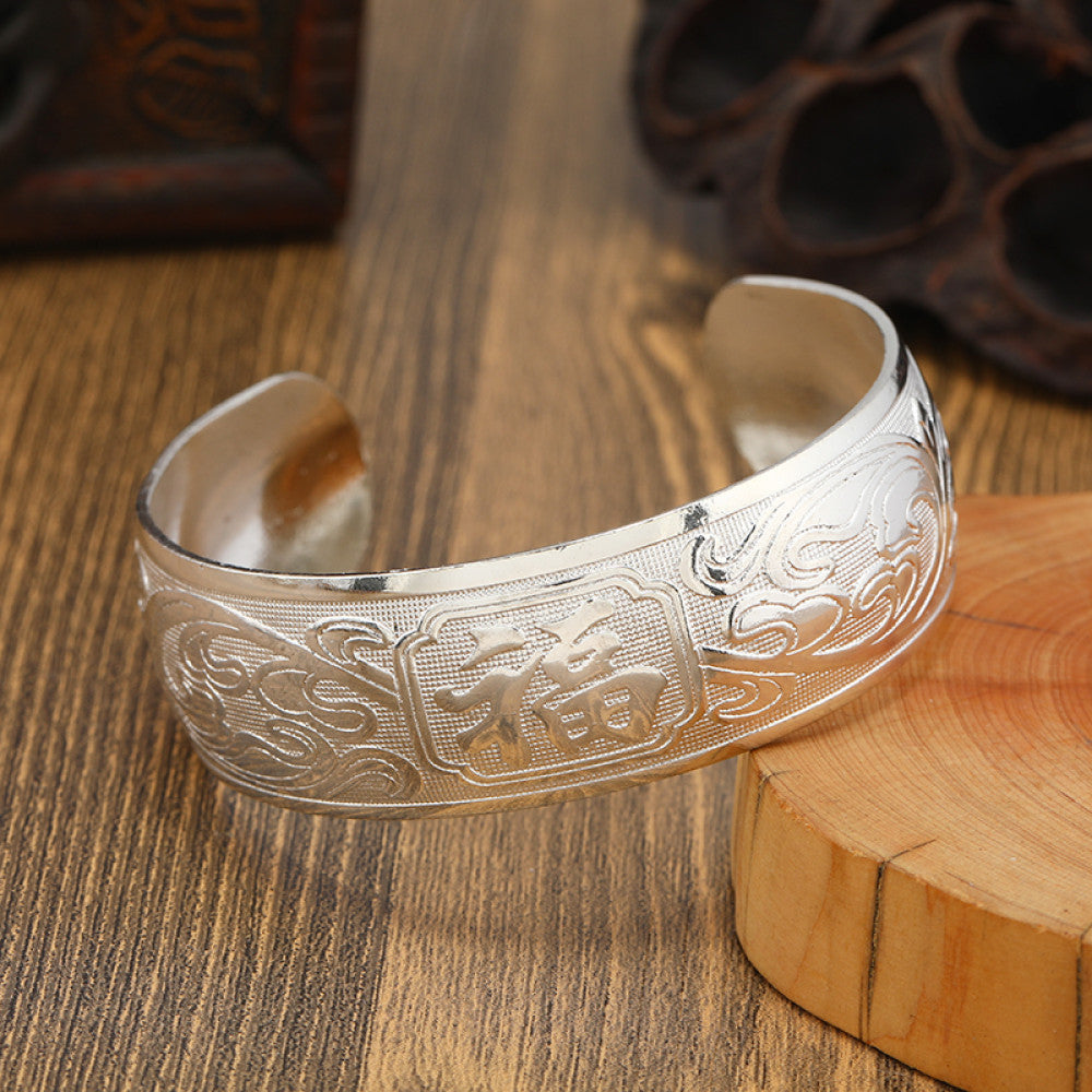 Boho vintage ethnic silver cuff bangle with tribal geometric engravings, styled on wooden surface, perfect for bohemian and tribal fashion lovers in the US 12