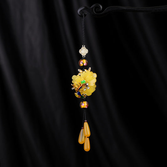 Boho vintage ethnic yellow-tone hair pendant featuring black cord, yellow flower-shaped charm (with multi-color gemstone & gold accents), and yellow teardrop pendants, styled against a black fabric background, ideal for bohemian and traditional fashion enthusiasts in the US