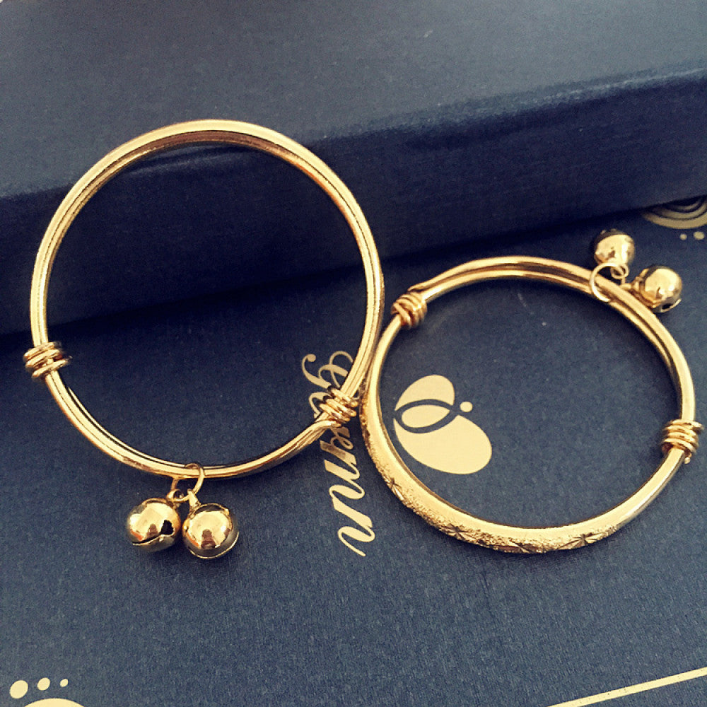 Boho vintage gold bangle set with bell charms, styled on a decorative black surface, ideal for bohemian and ethnic fashion enthusiasts in the US