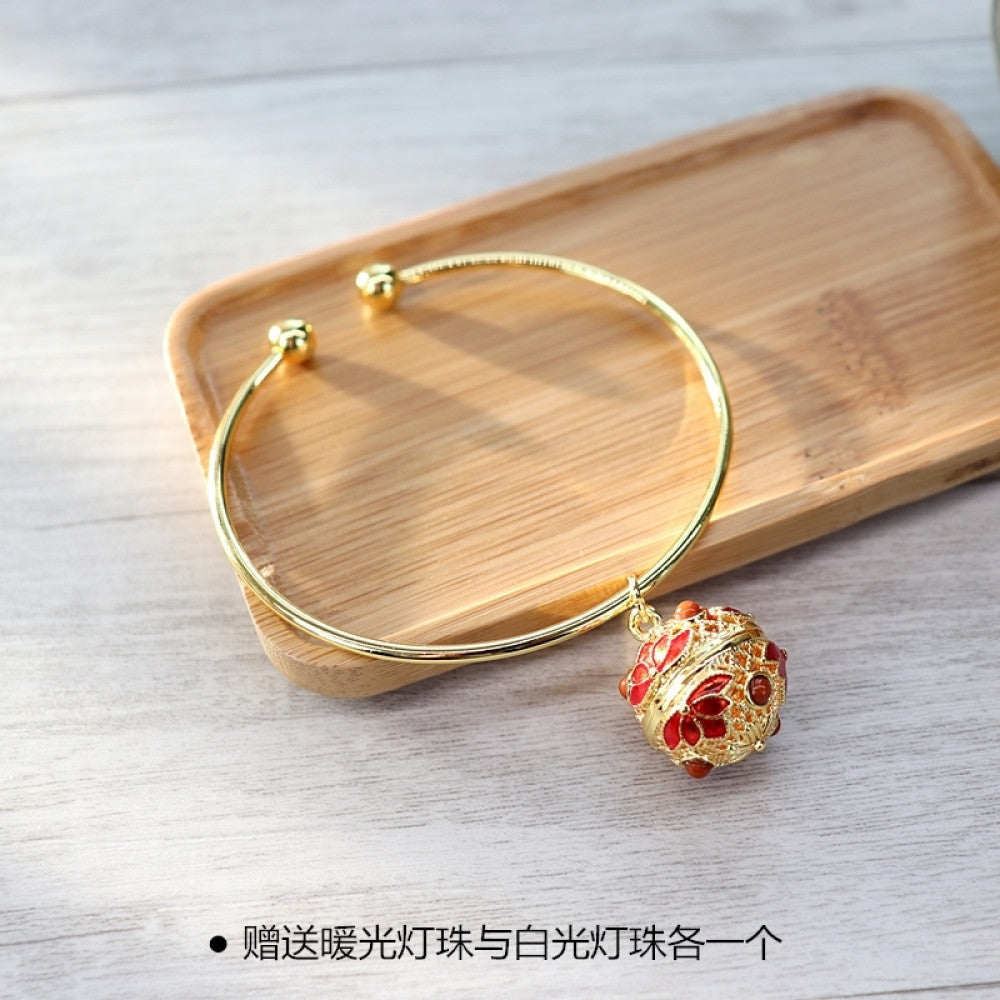 Boho vintage gold bangle with sakura locket charm, styled on wooden tray, ideal for bohemian and floral fashion enthusiasts 01