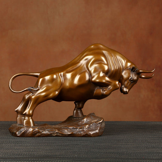Bronze bull statue with a powerful stance, a Feng Shui symbol of strength and good fortune, displayed as elegant home decor against a textured background