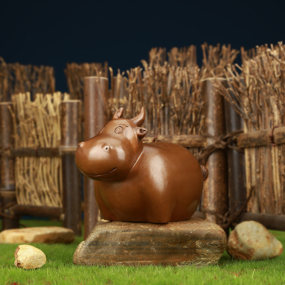 Charming bronze bunny statue with a rounded design, set against a rustic bamboo fence backdrop, a Feng Shui symbol of good fortune, ideal as whimsical home decor 01