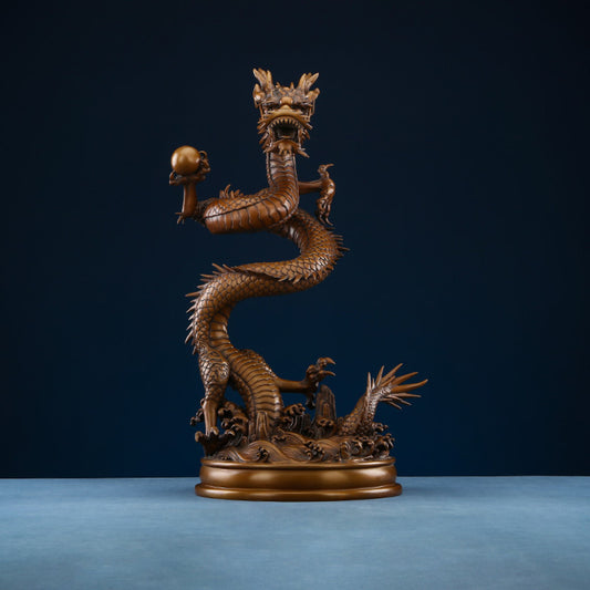 Intricate bronze Chinese dragon statue coiled around a pearl, a symbol of power and good fortune in Feng Shui, displayed on a blue surface against a dark blue background 01