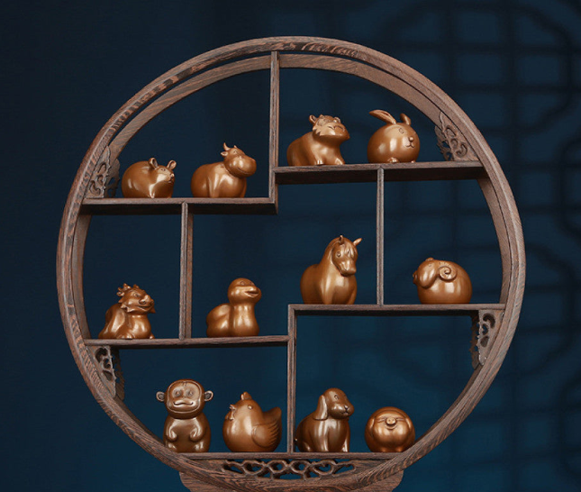Intricate bronze Chinese zodiac statues set in a circular wooden display, Feng Shui symbols of good fortune, displayed as elegant home decor against a dark blue background