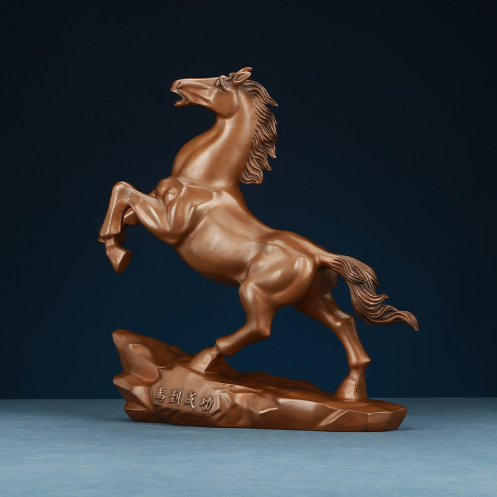 Bronze horse statue with a rearing stance, a Feng Shui symbol of success and achievement, displayed as elegant home decor against a dark blue background