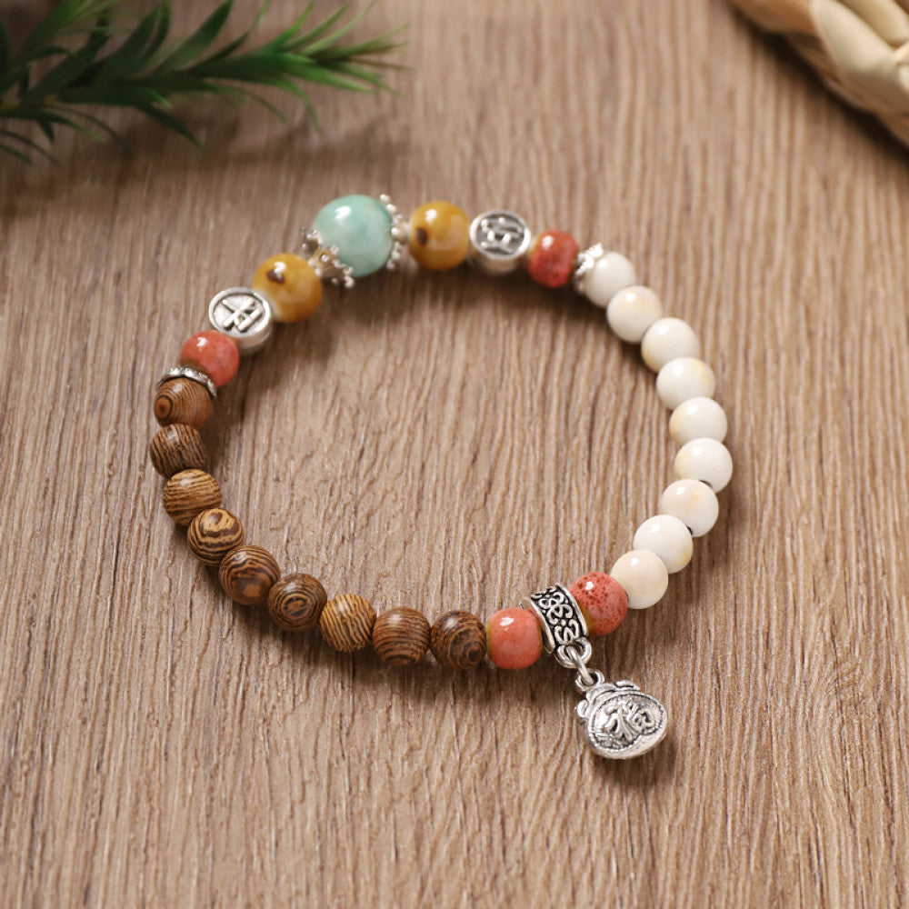 Earthy brown and white beads with a red dot, natural and calm.